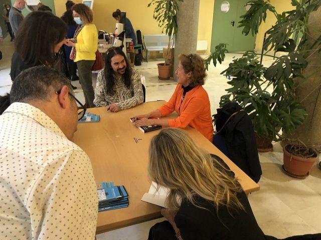 Berna González, de naranja, firmando libros en Cuenca
